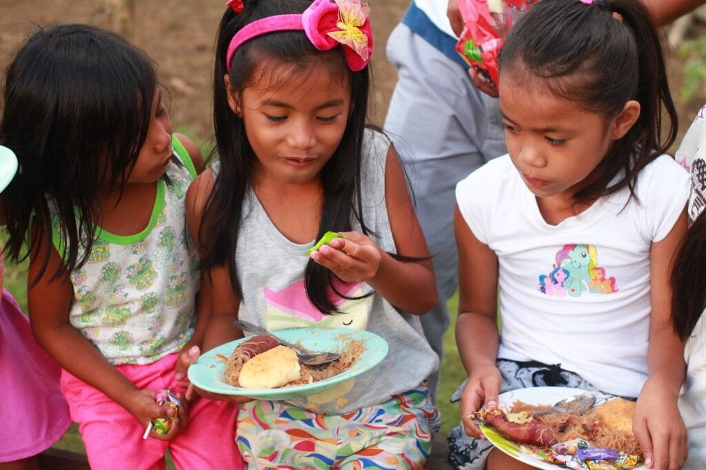 Children sharing a meal during a community feeding activity
